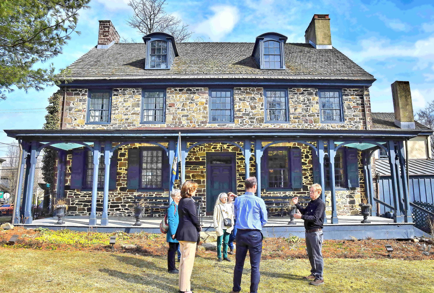 A group assembles at the rear of the mansion for a tour led by Roy Ziegler.