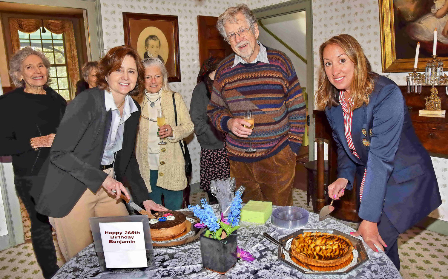 Board member Kay Weeder, left, and Cindy Hall, executive director, New Hope Historical Society, right, cut the cake