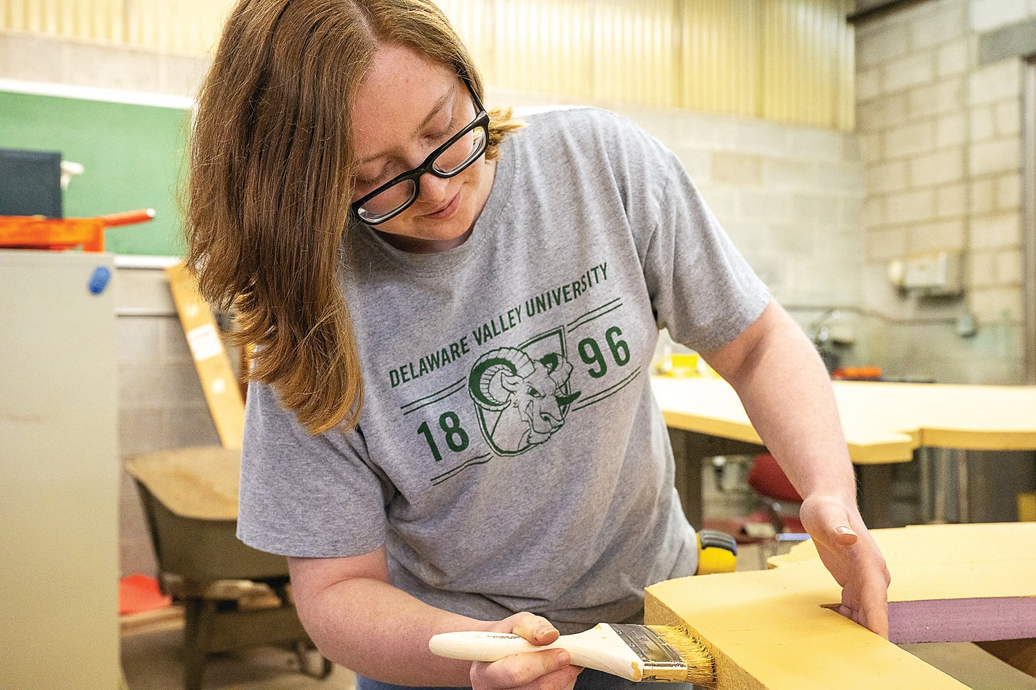 Kayla Bauman, a horticulture major, paints one of the props for the Delaware Valley University exhibit at this year’s Philadelphia Flower Show at the Pennsylvania Convention Center.