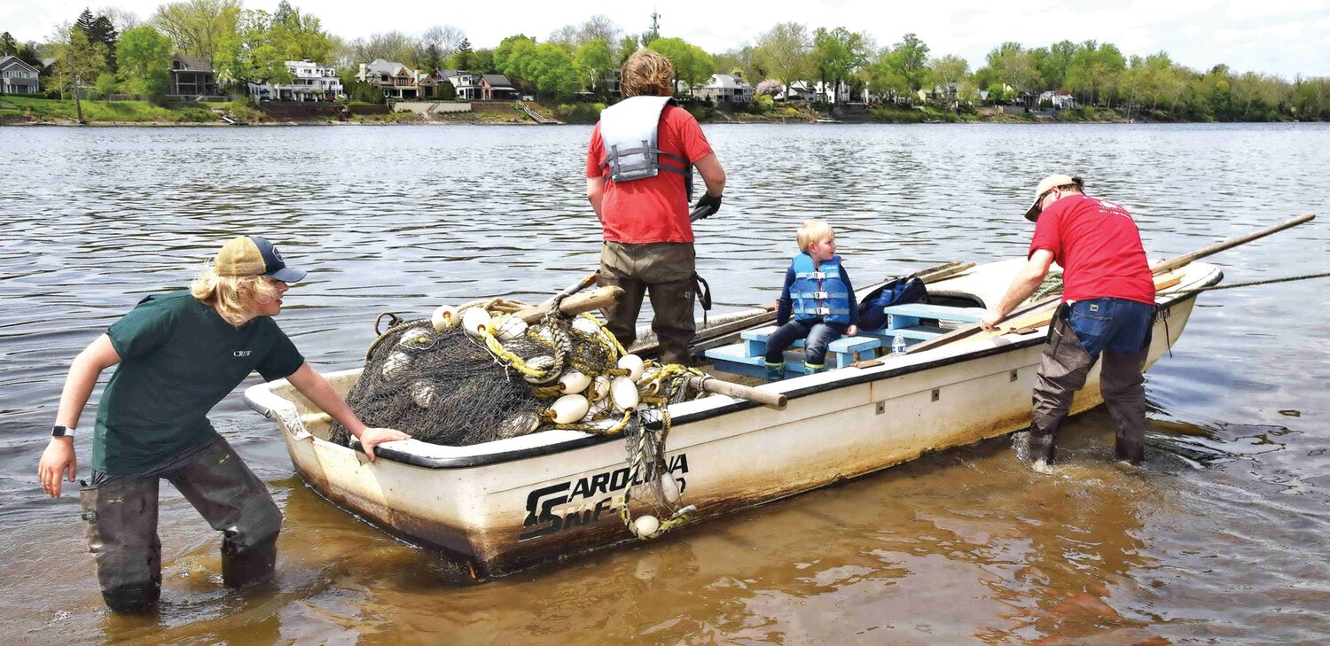 Members of the Lewis Fishery crew go off to place nets to catch shad.