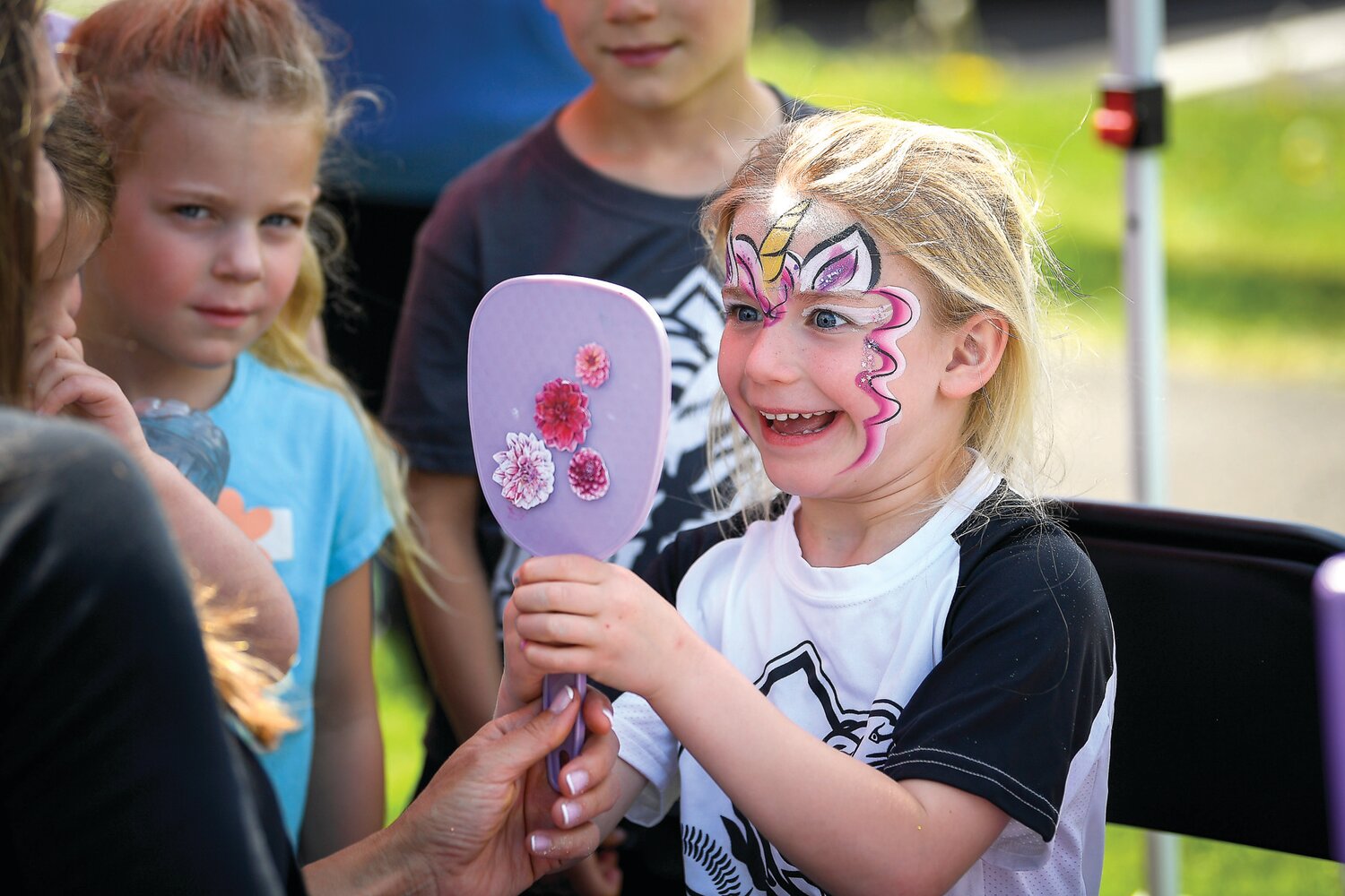 A young girl checks out her new face paint.