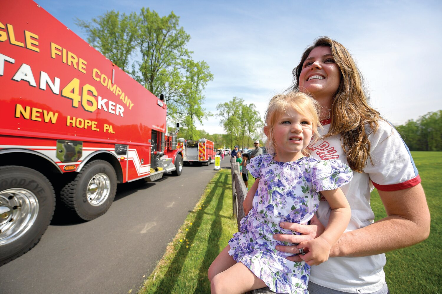 Maggie Strizki, 2, held by her mom, Kaitlin, has the best seat the start of the parade.