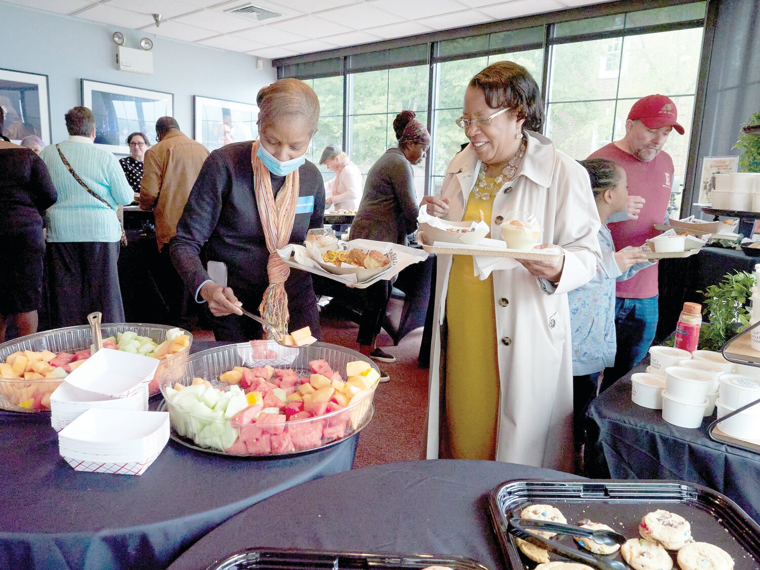 Cynthia Smith, of Burlington, and Gladys Stewart, of Willingboro,  fill their plates at the “Chicken & Biscuits” Community Jam on April 30 at the Bristol Riverside Theatre.