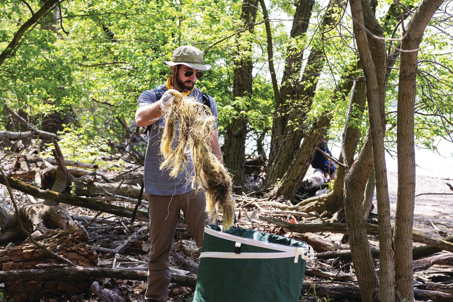 A teacher volunteer from the Bucks Learning Cooperative helps clean up trash on Burlington Island.