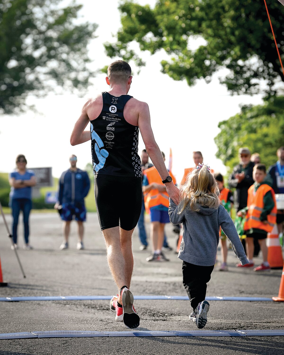 Chris Mallard of Philadelphia, the 5K overall race winner (15:07), crosses the finish line with his daughter.