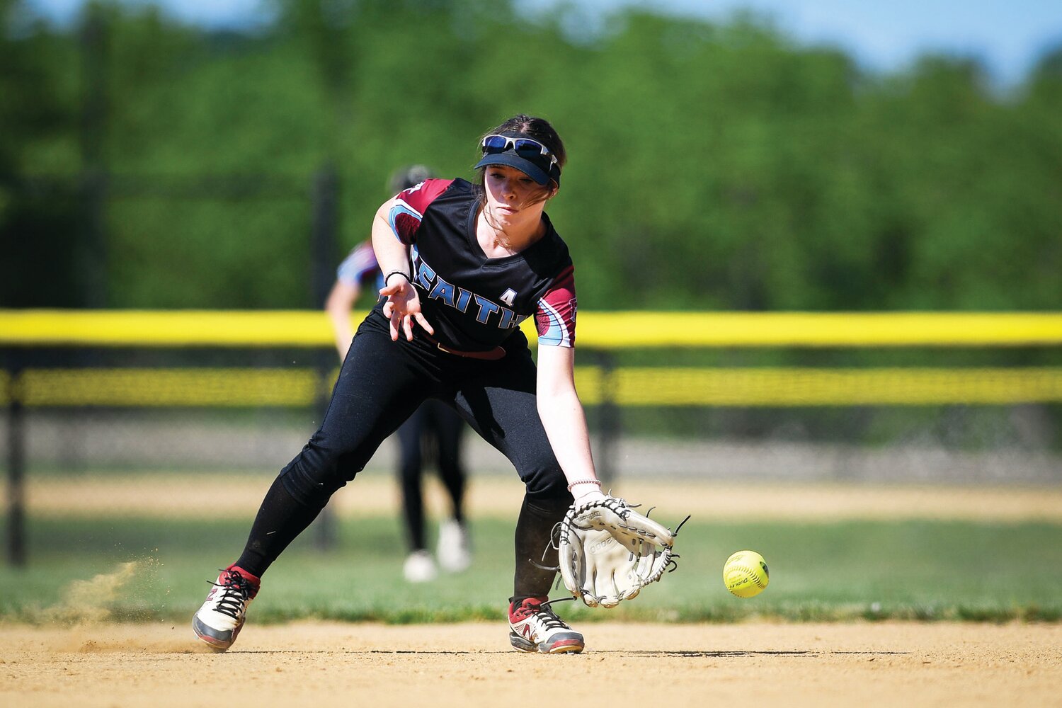 Faith Christian shortstop Olivia Michalski tries to field a tough grounder.