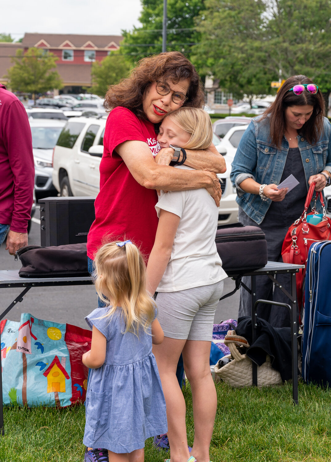 One of her music students gets a hug from “Miss Marilyn” Schwartz on the day of her final class in Lower Makefield with Kids’ MusicRound.