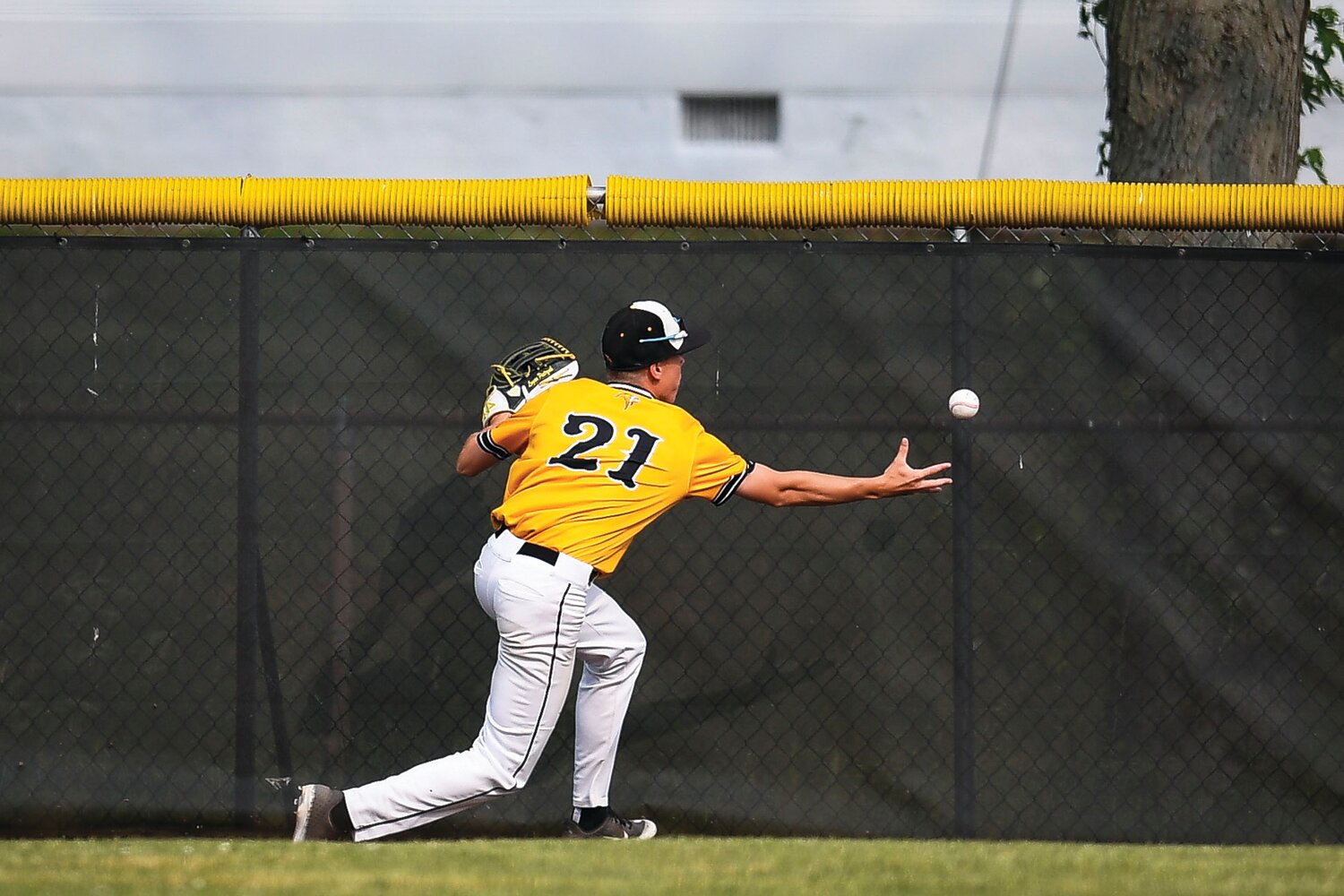 Archbishop Wood left fielder Logan Pietrzak tries to gather a ball hit off the left field wall.