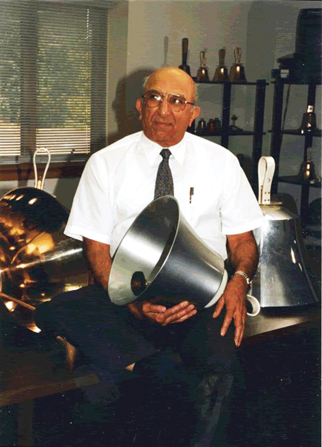 Malmark founder Jack Malta with an aluminum handbell.