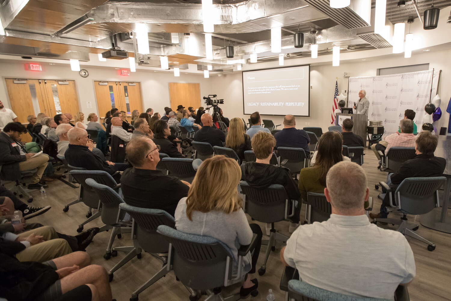 Invitees listen to The Bucks County Music Project founder Richard Towey present at the nonprofit's inaugural meeting Monday night in Buckingham.