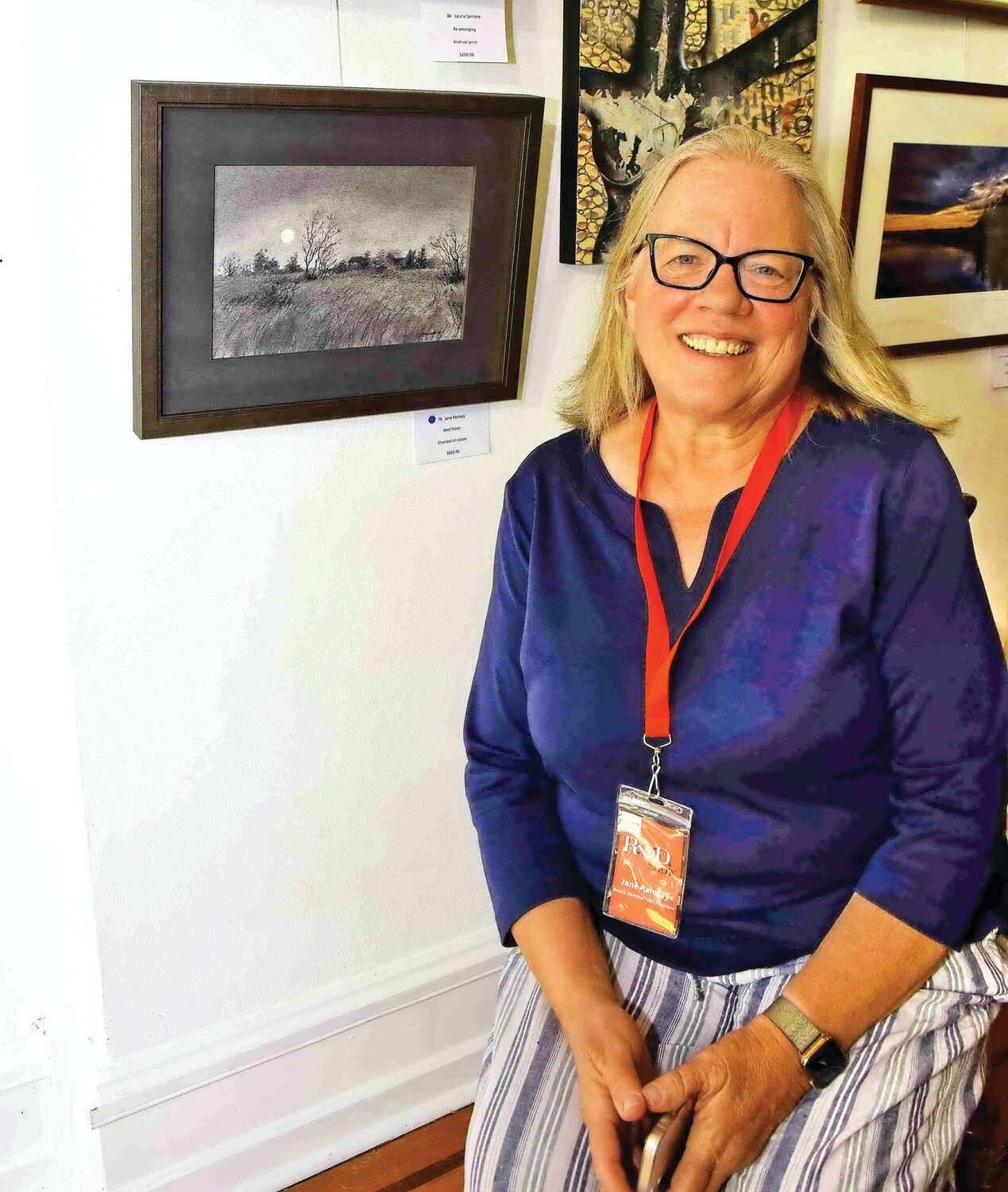 Artist Jane Ramsey next to her charcoal drawing on paper, “Wolf Moon.”