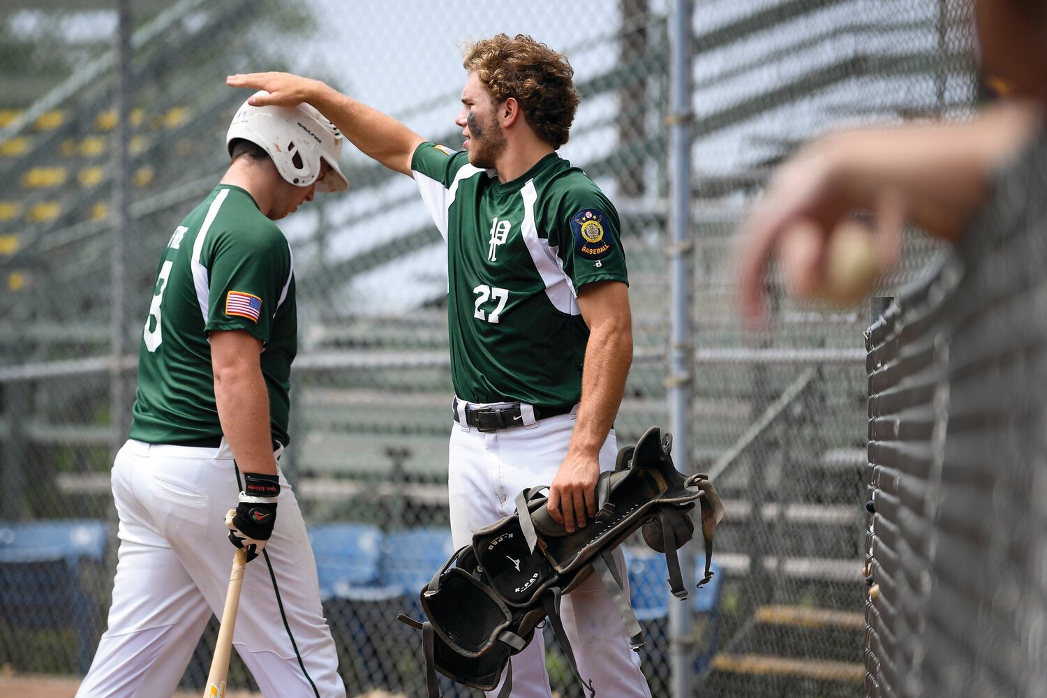 Pennridge’s Nate Lapp pats Aidan Fretz after scoring during Game 1’s seven-run fourth inning.