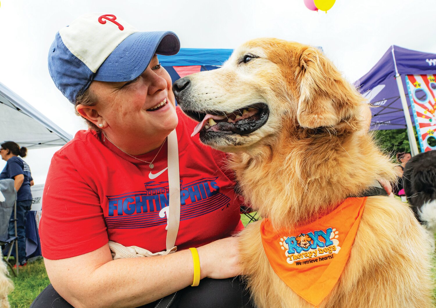 Casey McCullion comforts Horton, a trained Roxy Therapy Dog. Roxy Therapy Dogs is an all-volunteer nonprofit group that offers a support system for children and teens in the Central Bucks community. Those attending the Village Fair got a chance to meet and mingle with volunteers and three of the organization's therapy dogs.