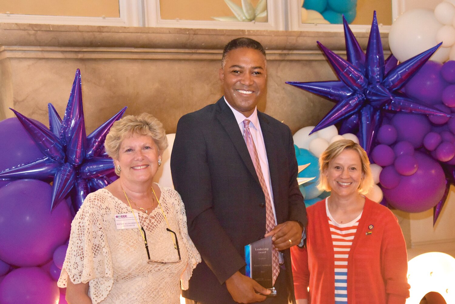 Commissioner Kenneth E. Lawrence, center, accepts the Leadership Award from Sen. Marie Collett, left, and Wendy Klinghoffer, EMCCC executive director.