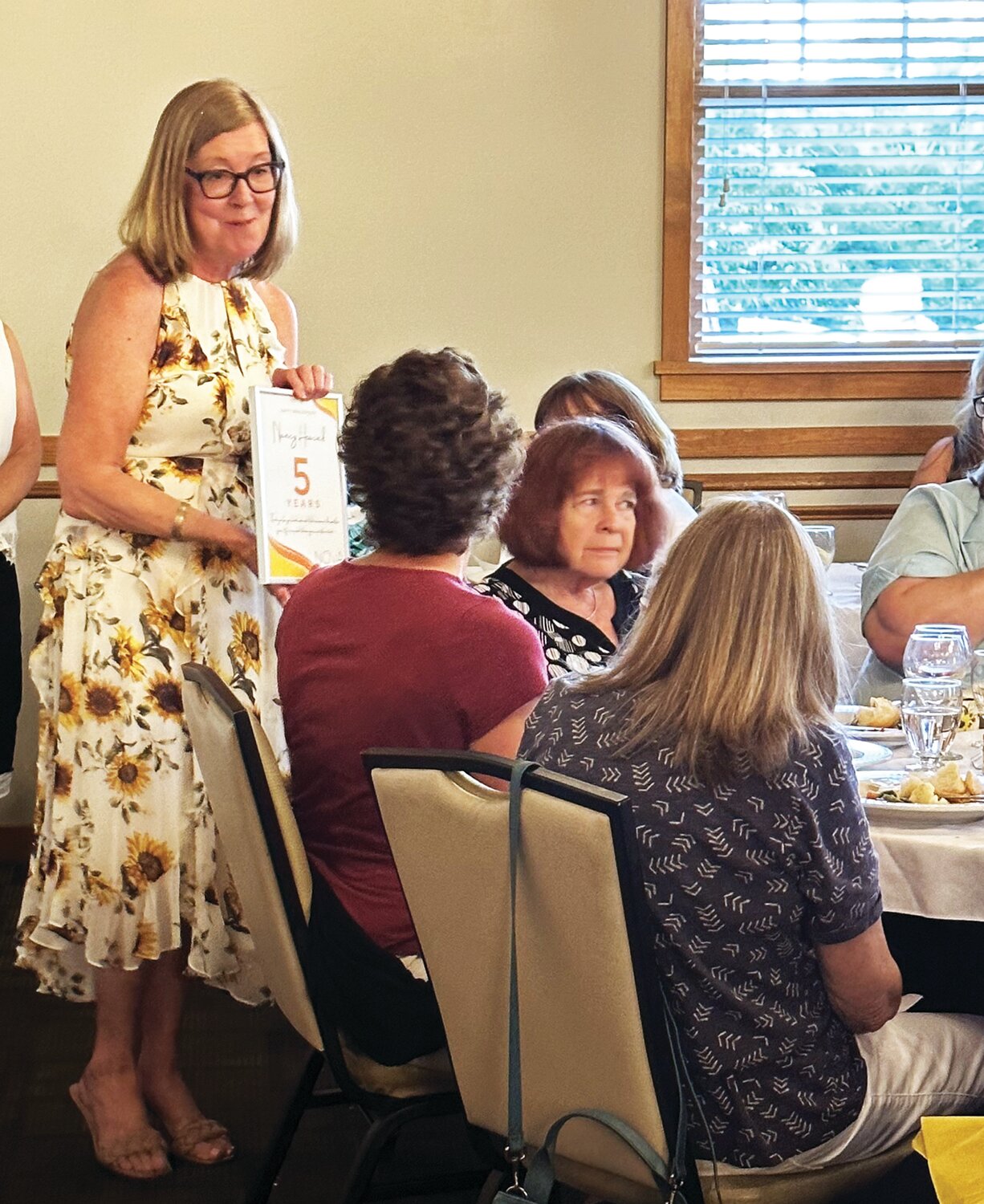 Julie Dugery, NOVA volunteer and community outreach coordinator, presents Nancy Heacock, a Helpline volunteer, with a five-year anniversary certificate.