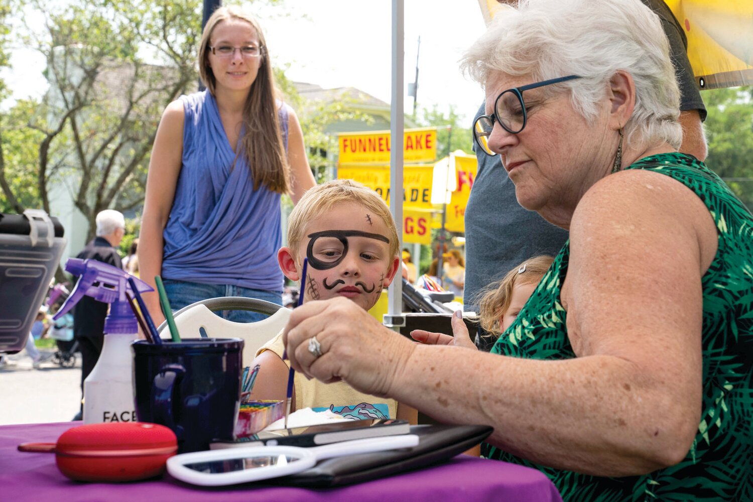 A child gets his faced painted at Peddler’s Village’s 2023 Peach Festival.