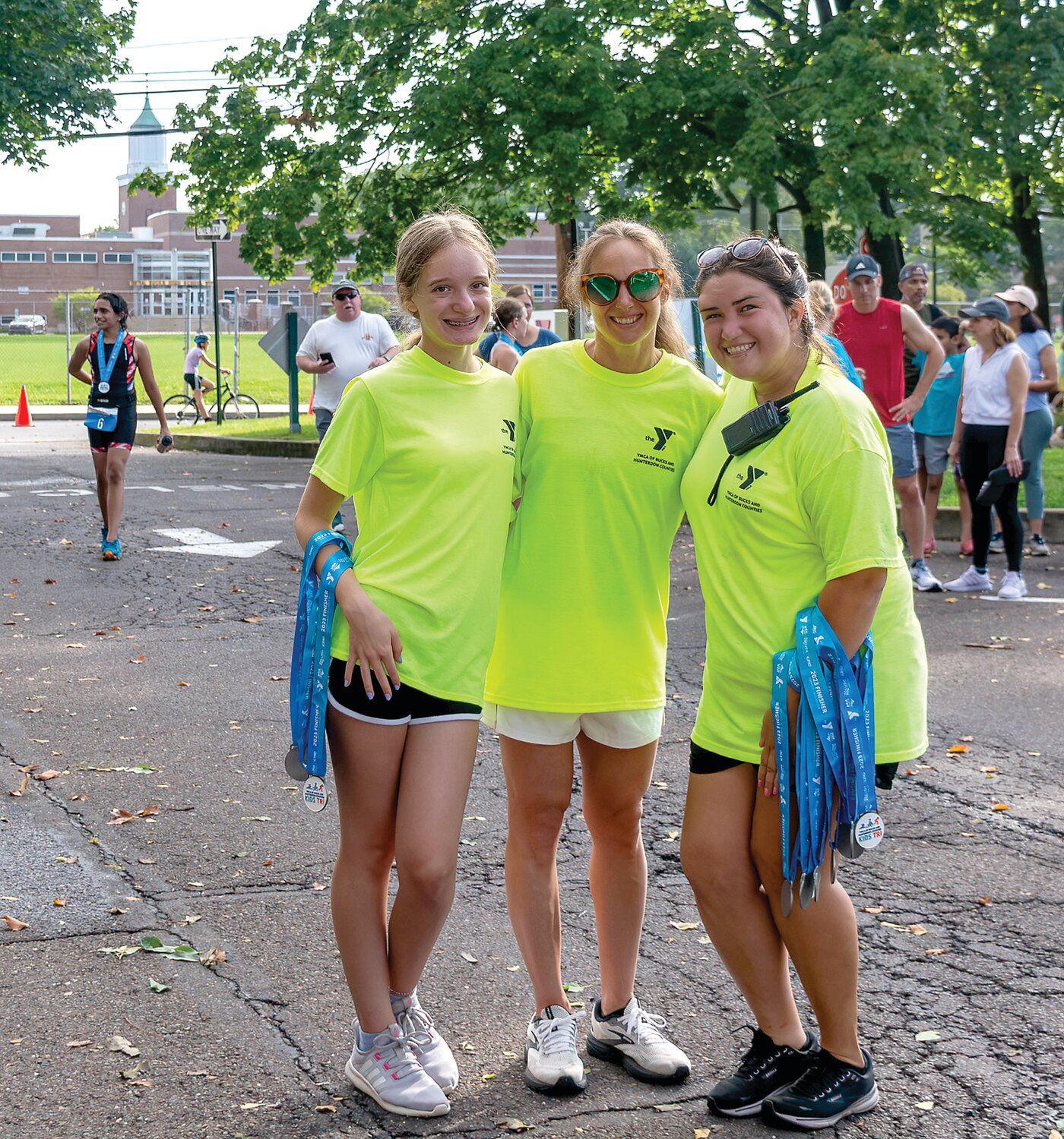 Volunteers Kaitlyn Stevens, Andrea Brown and Chelsea Grayson get ready to hand finisher medals to the athletes at the end of the race.