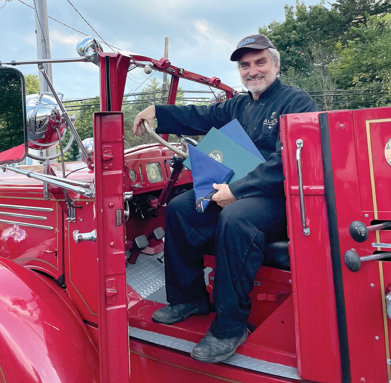 Caleb Lentchner aboard a vintage fire truck.