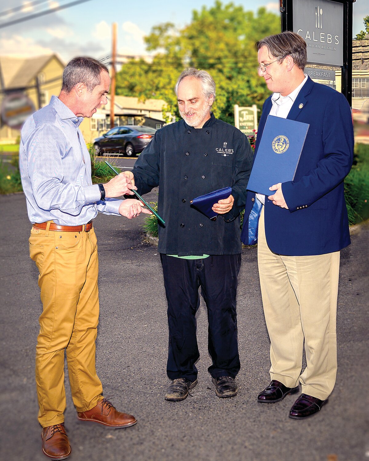 State Sen. Steve Santarsiero, left, and state Rep. Tim Brennan, right, present citations to Caleb Lentchner, center, owner of Caleb’s American Kitchen.