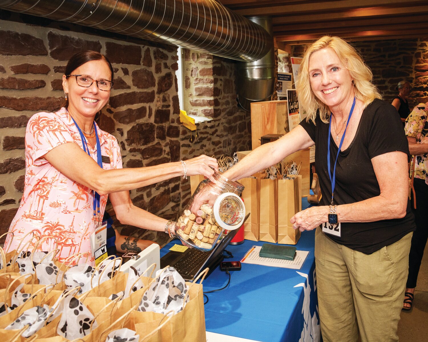 Maria Wirths, Bucks County SPCA’s board president, offers a wine cork to Mary Ann Robinson.