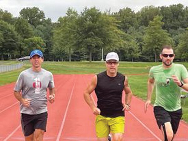 Bucks County Roadrunners Club runners, from left, Paul Lancaster, John Molnar and Sam Cler warm up for some mile repeats on a Tuesday night at Council Rock High School South.