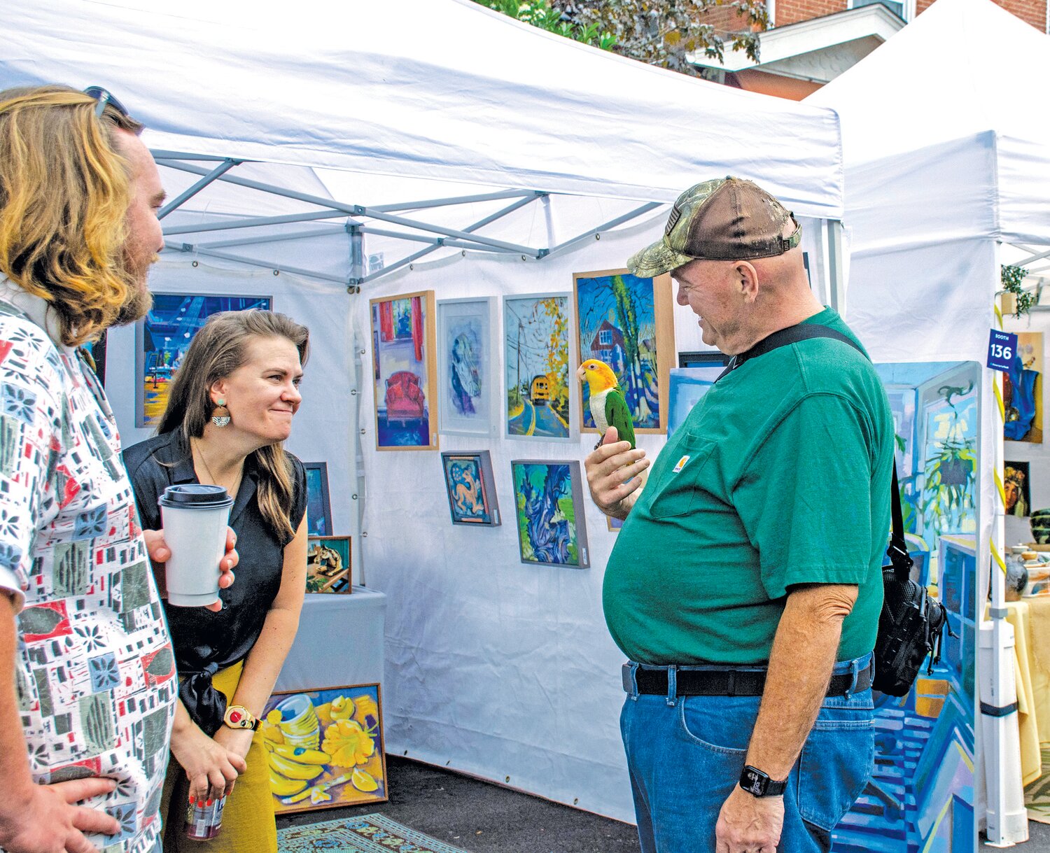 A festival goer and his pet parrot
check out various vendors.