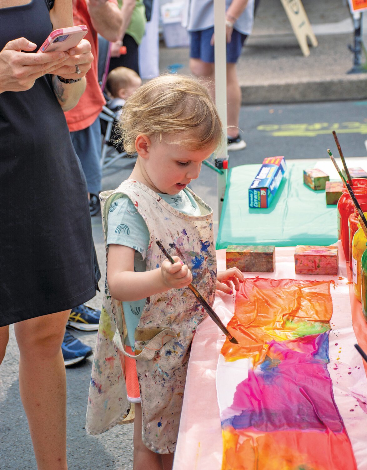 Charlotte Hobbs paints a scarf at the Michener Art Museum
booth.