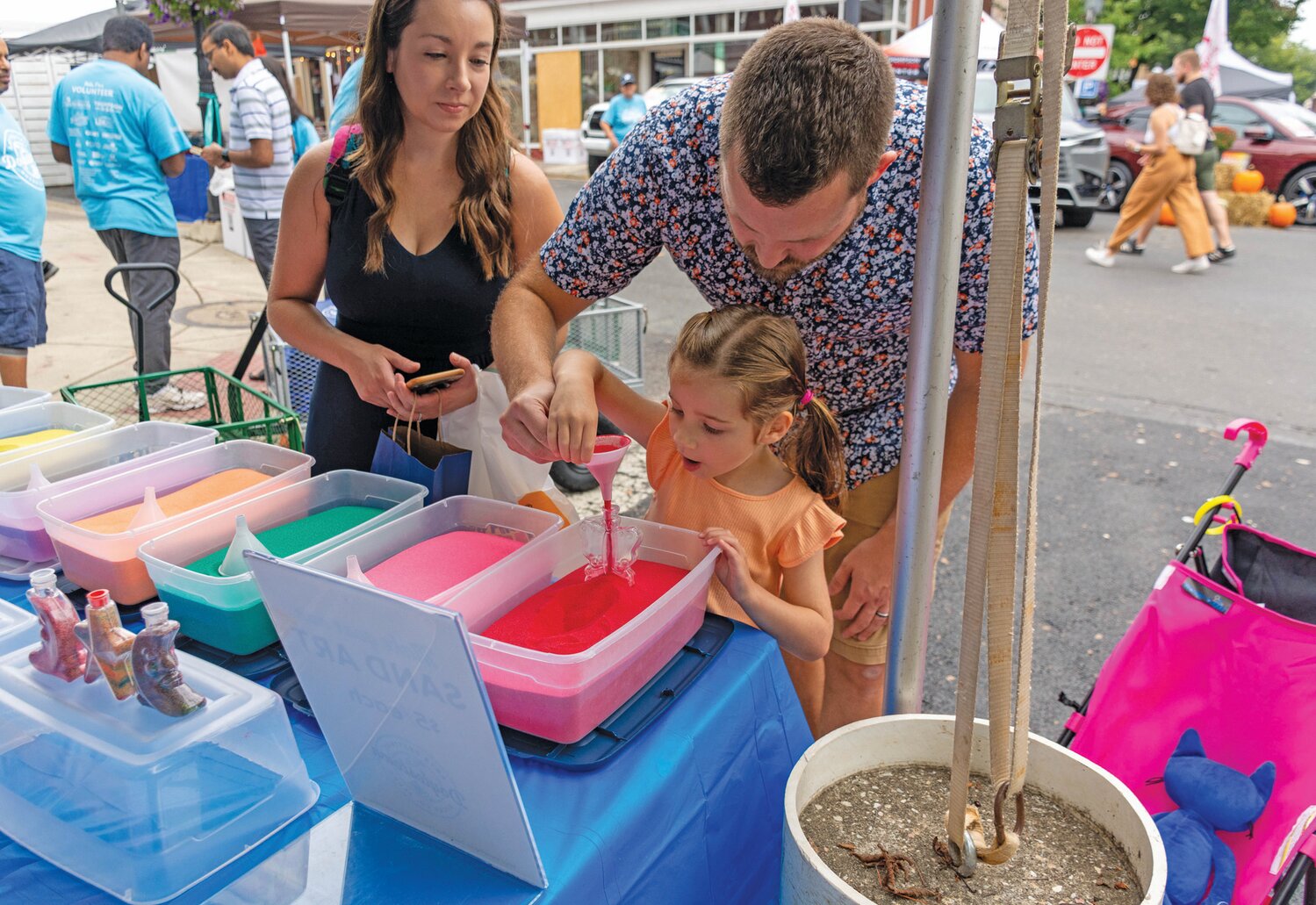 Lauren and Ben McComsey watch their daughter, Sophia, create sand art.