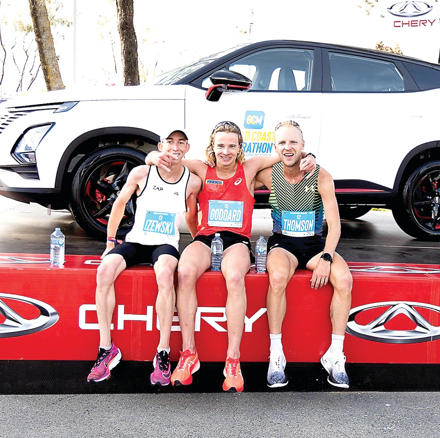 Josh Izewski, left, gets together with Australia's Ed Goddard (center, 2:12.5) and Jacob Thomson (2:11.40) after the Gold Coast Marathon in Australia.