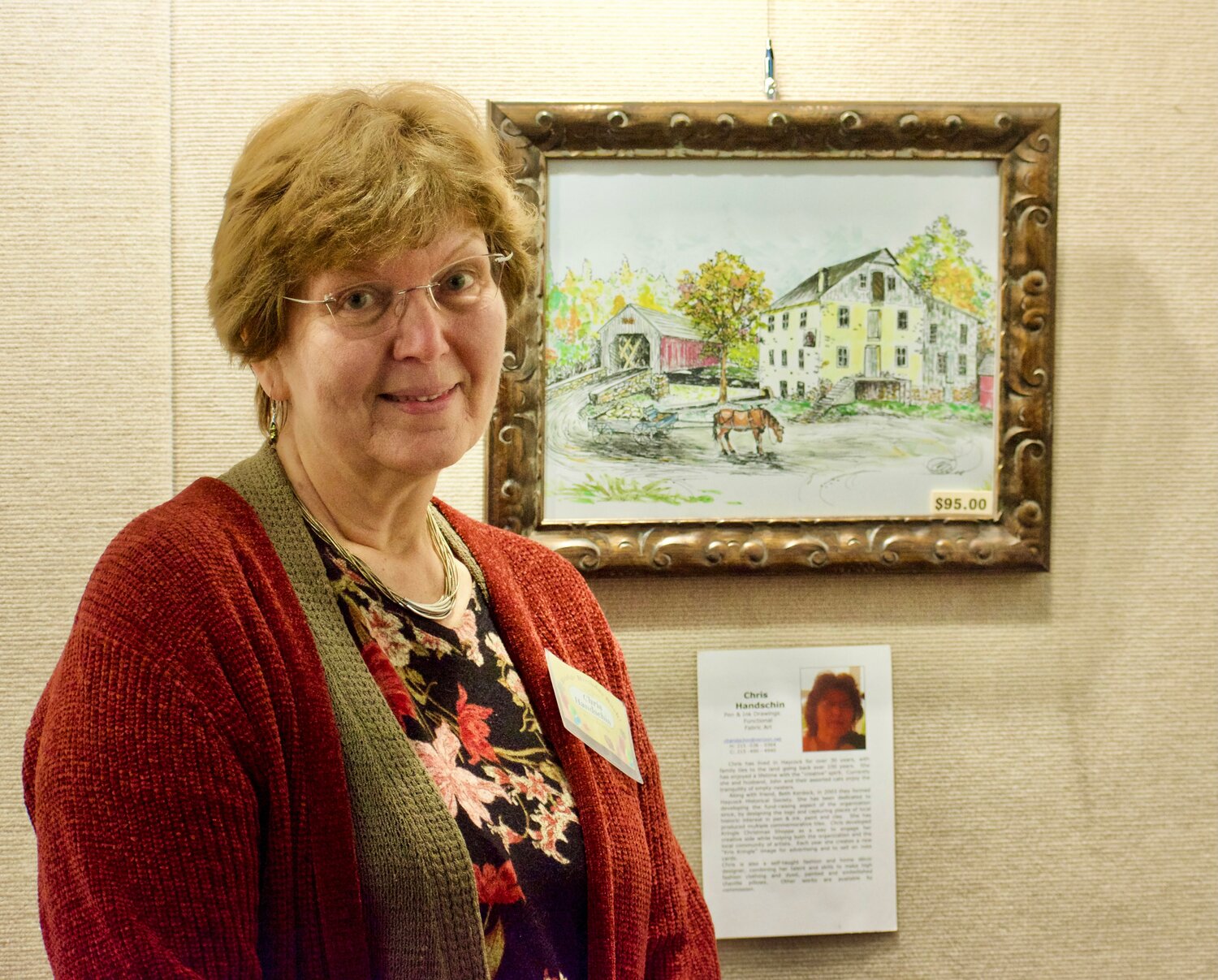 Artist Chris Handschin poses with her watercolor of the Sheard’s Mill Bridge, during Saturday’s birthday celebration for the 150-year-old span.