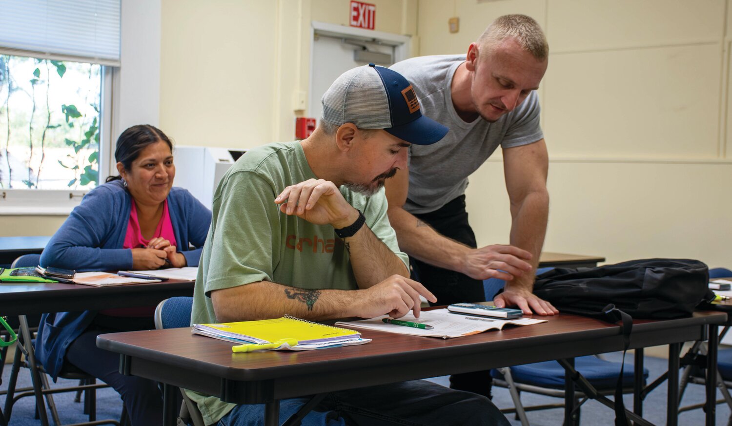 Student Shawn Retzler helps classmate Nathan Duran with a problem during a session at Vita’s Croydon site.