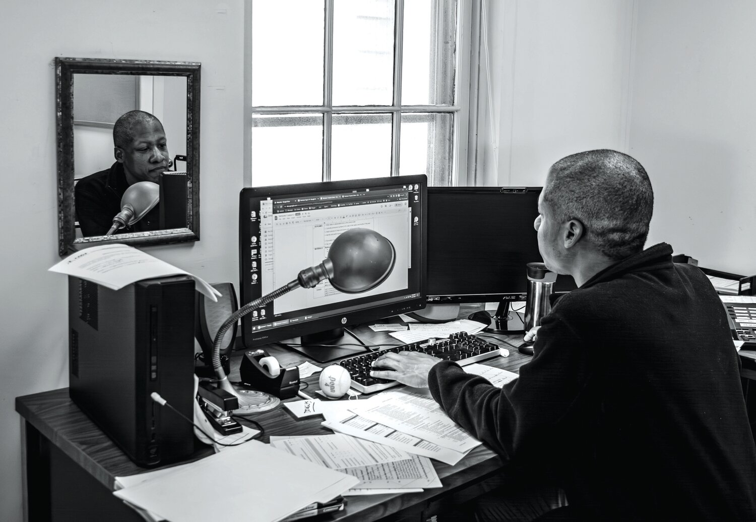 Douglas Green, ESL Tutoring Coordinator, works at his desk in Doylestown.