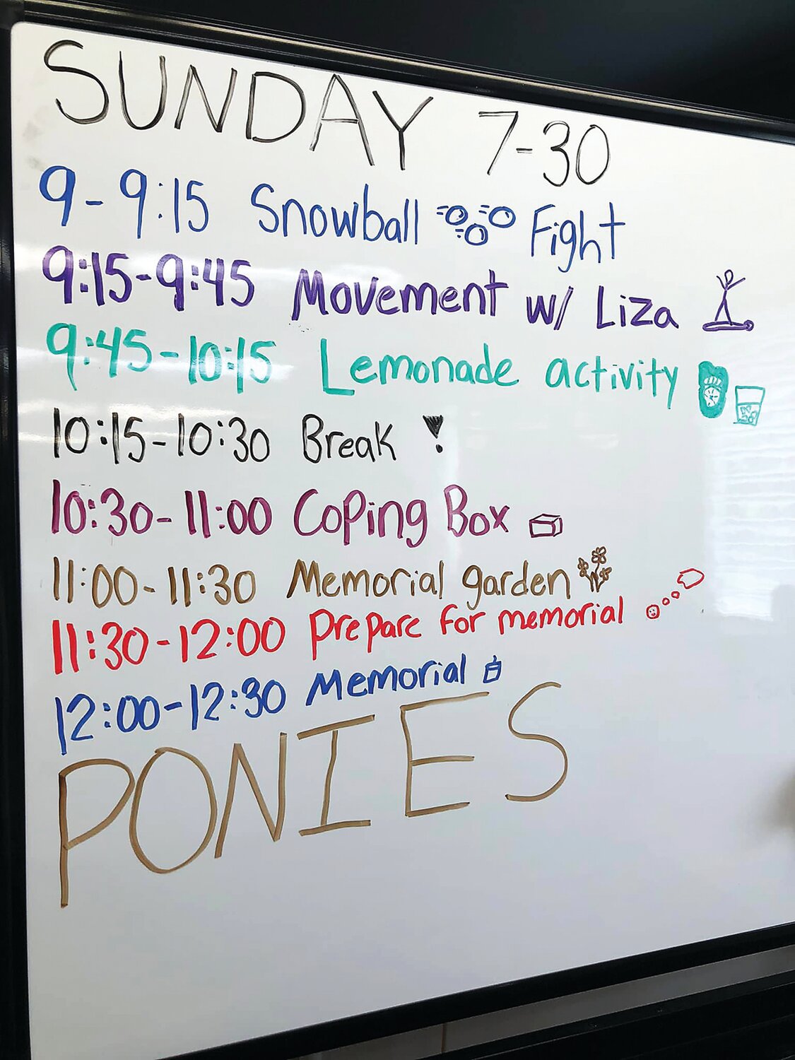 A whiteboard provides the July 30, 2023 schedule at Camp Feeling Better.