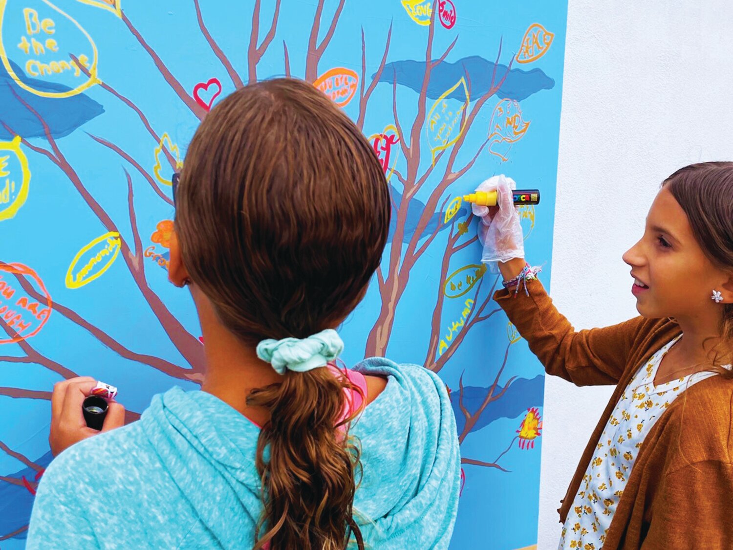 Upstander Day attendees add positive messages of support to a living mural from the Bucks County Anti-Racism Coalition.