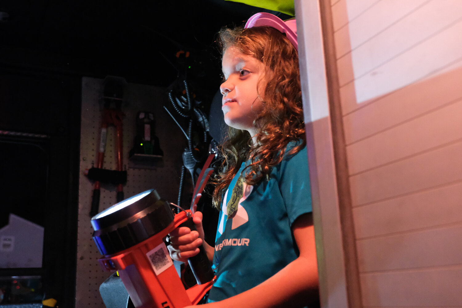 Eight-year-old Jillian Cunningham, of Middletown, gets to try the equipment in a firetruck.