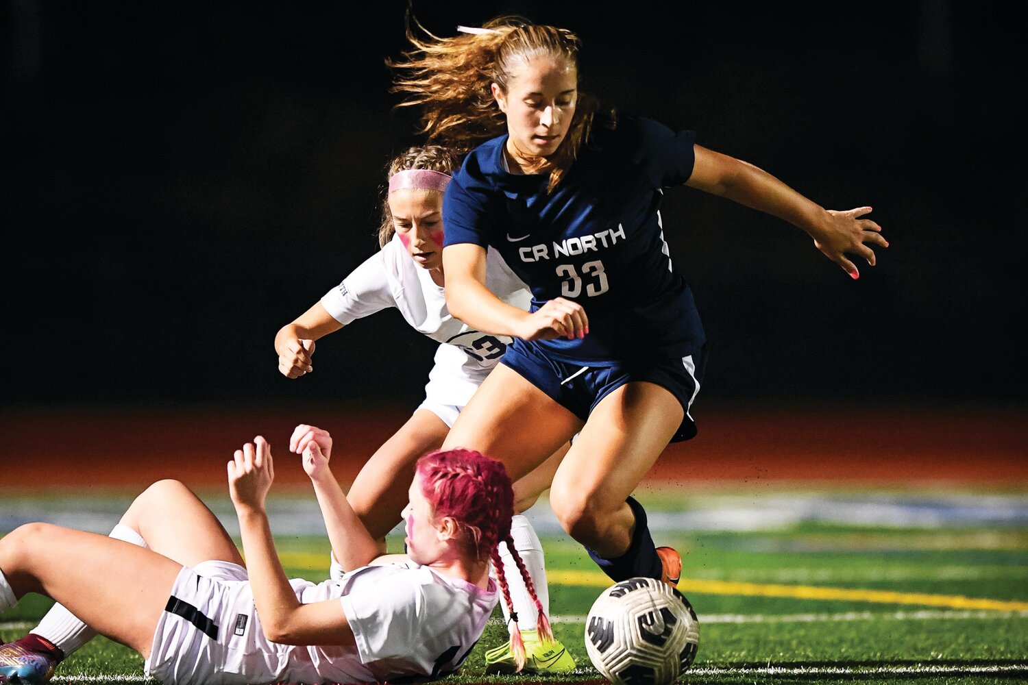 Council Rock North’s Mia Cairone tries to get around a fallen Teagan Shay of Council Rock South as Shay’s teammate, Gianna Kirlin, chases from behind.