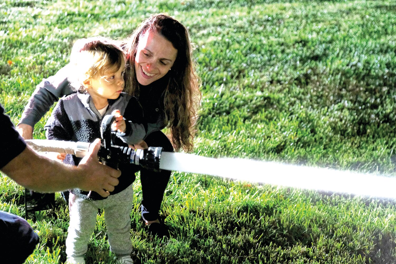 Maria Lacovara, of New Hope, helps her son Dominic work the fire hose.