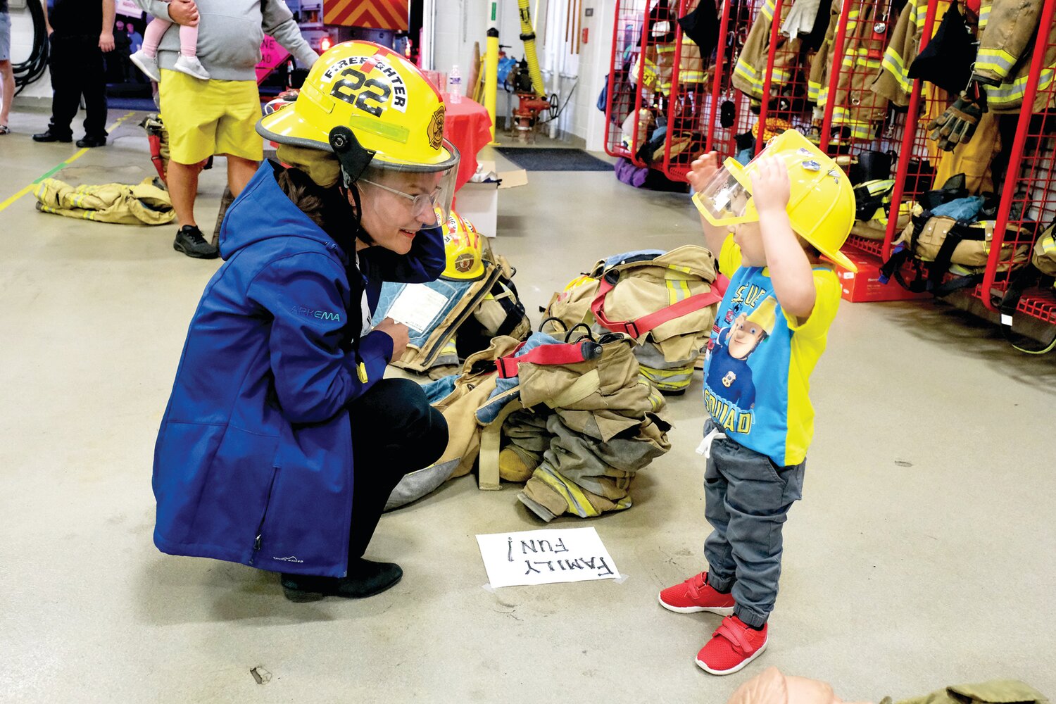 Jessica DeMott and Cameron MacInnis, 3, of Middletown, try on the equipment.