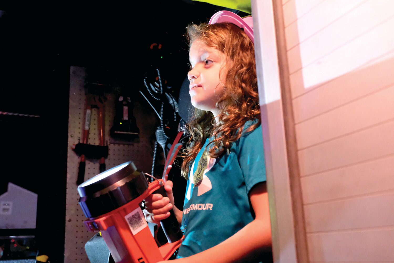 Eight-year-old Jillian Cunningham, of Middletown, gets to try the equipment in a firetruck.