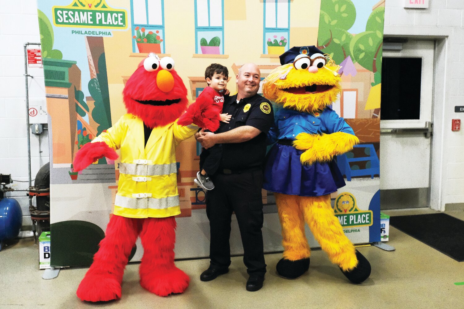 Pat McWilliams, with his 3-year-old son Declan, poses with Elmo and Zoe, from Sesame Place.