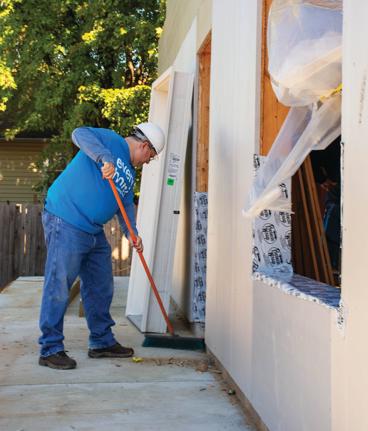 Volunteer David Abernethy sweeps at the project site.