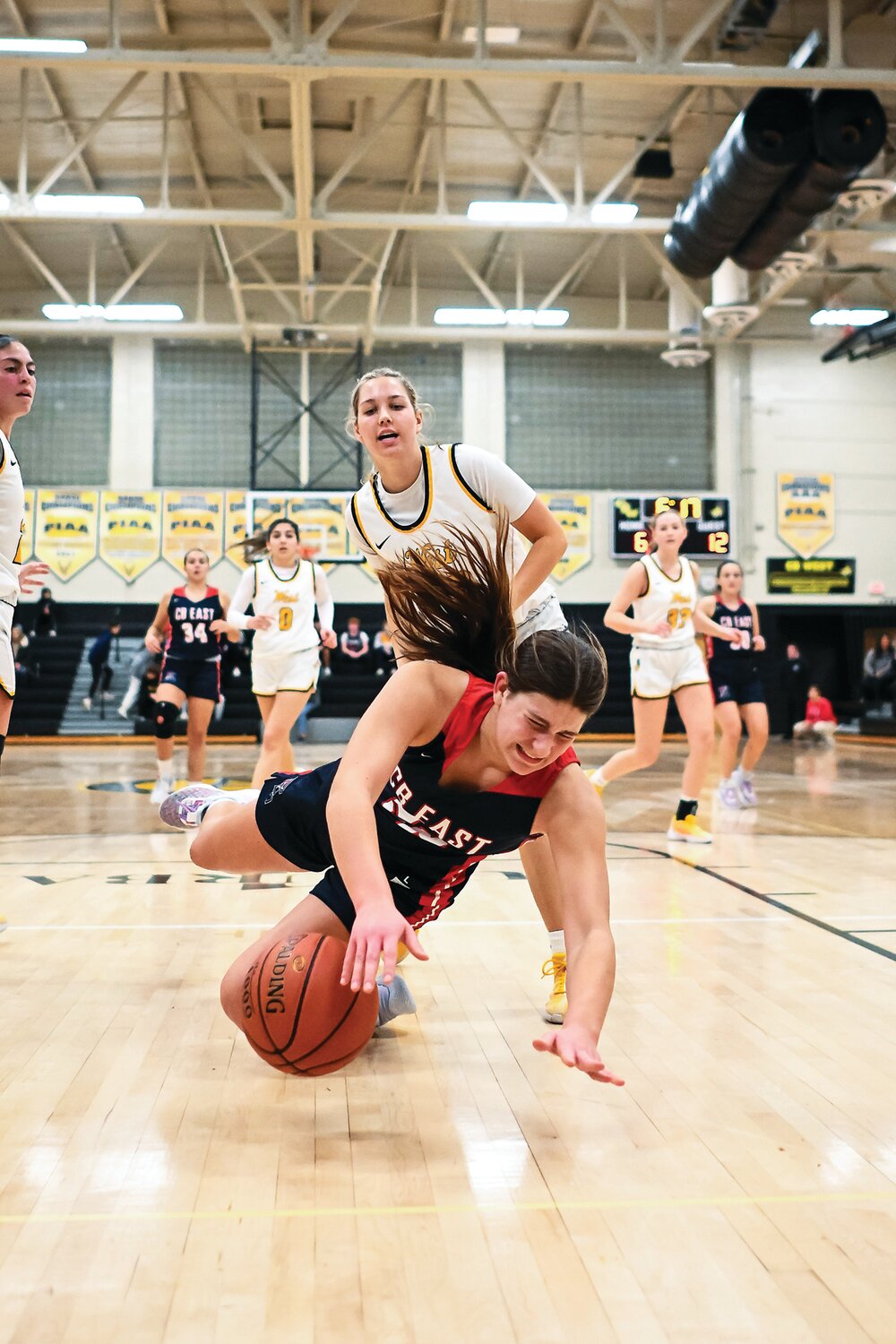 Central Bucks East’s Chantal Van Dongeren crashes to the court after chasing a loose ball in front of Central Bucks West’s Gabrielle Reichner.