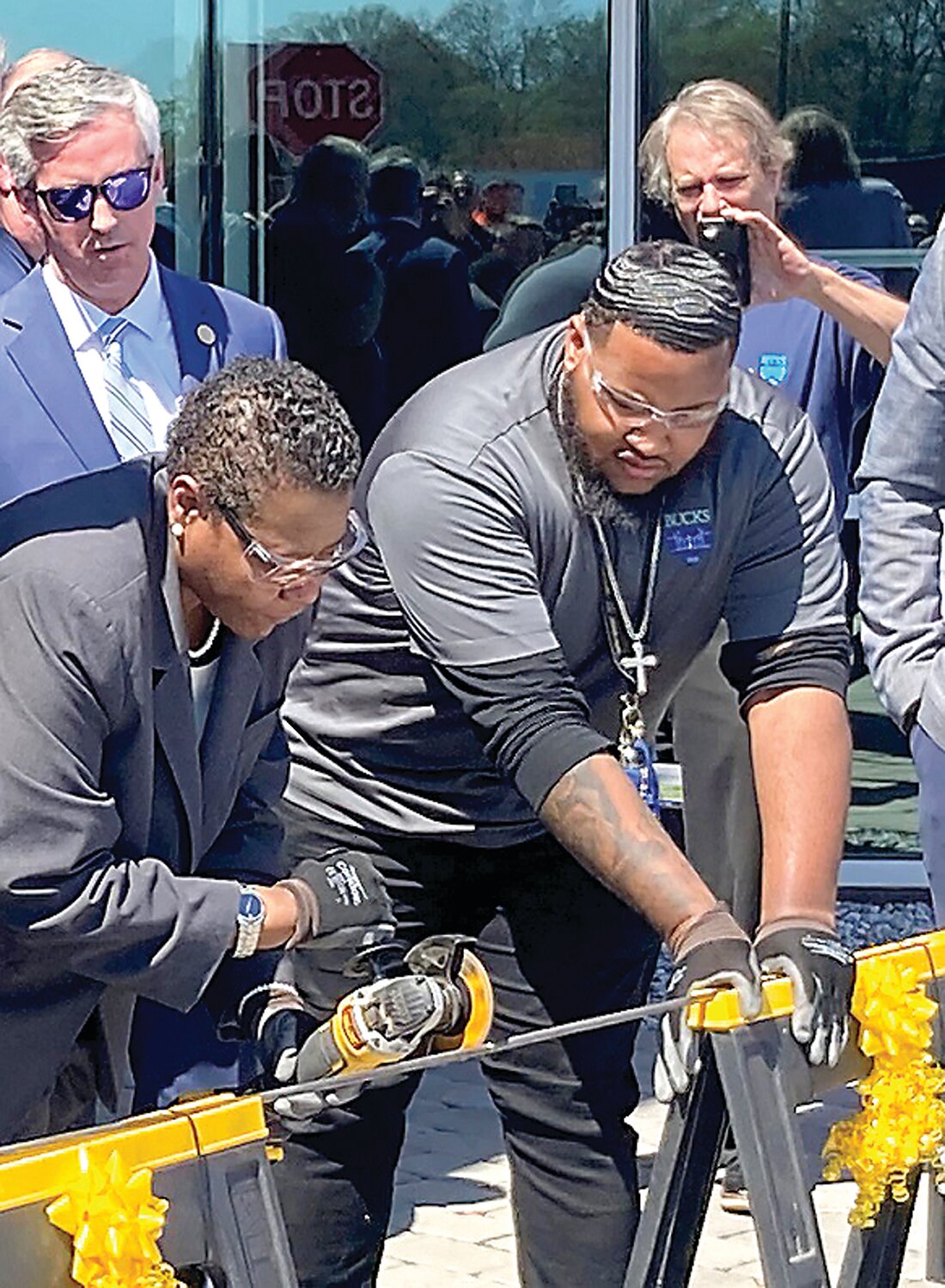 Bucks County Community College President Felicia L. Ganther puts a polish on the traditional ribbon cutting by slicing through a metal rod with a special power saw at the ceremonial unveiling of the college’s new Center for Advanced Technologies in Bristol Township.