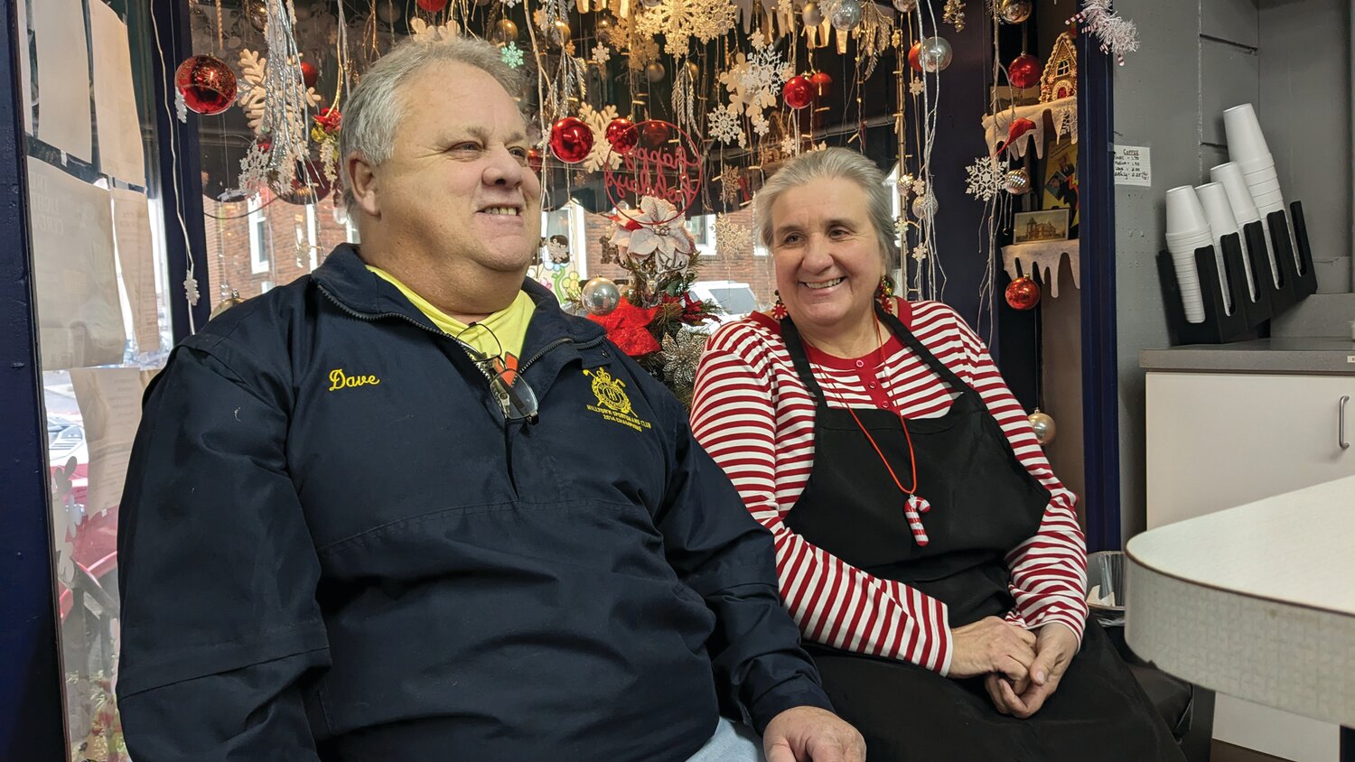 Dave Myers talks about the community effort to sustain his Arch Street Deli during his seven weeks in the hospital and a rehab facility as resident Dee Fell Smith looks on. Smith was a key member of the team of volunteers that kept the deli humming.