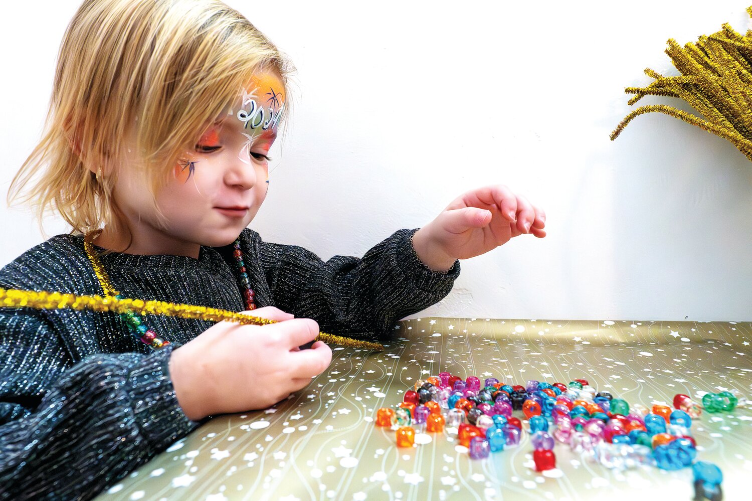 Olivia Adelman makes jewelry after the balloon drop.