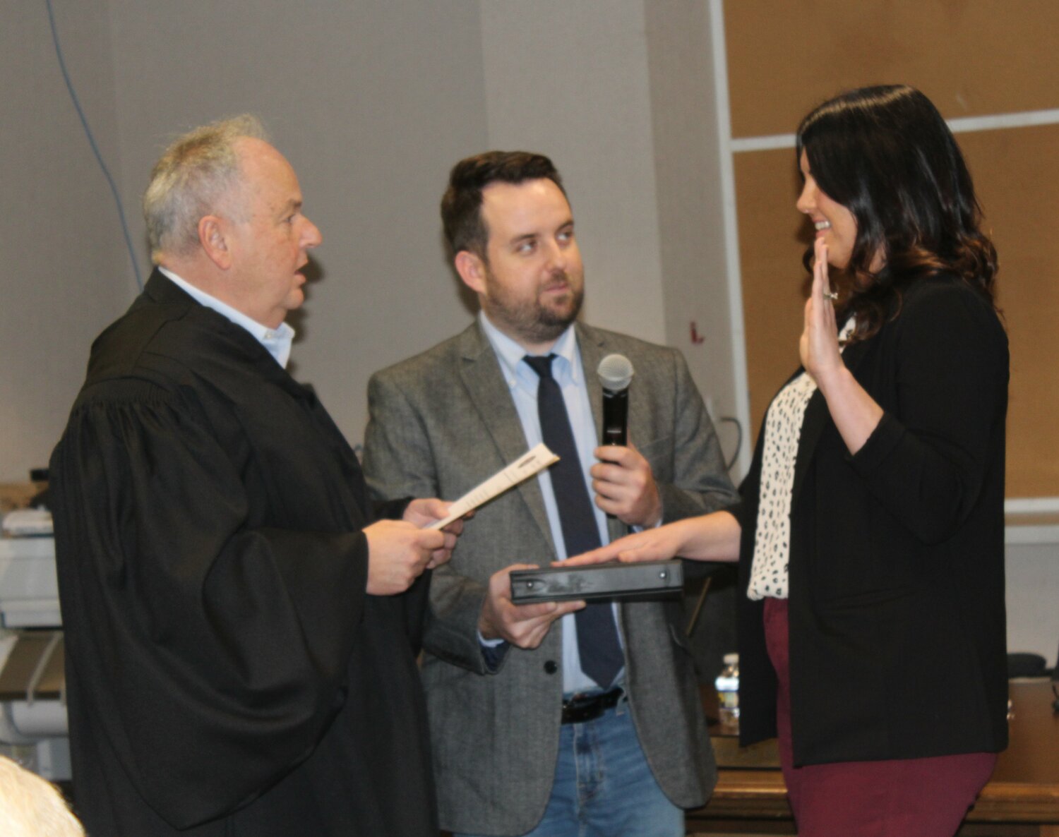 District Judge John Galloway administers the oath of office to Falls Supervisor Erin Mullen while Stephen Seufert holds the Bible.