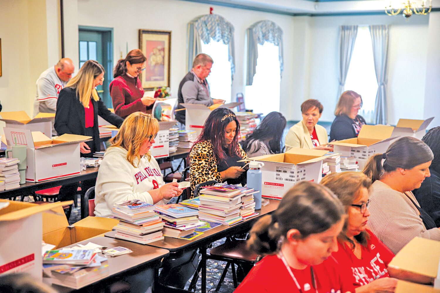 The Books for Kids Program committee labels each book with the donors’ names inside the book’s front cover prior to distribution.