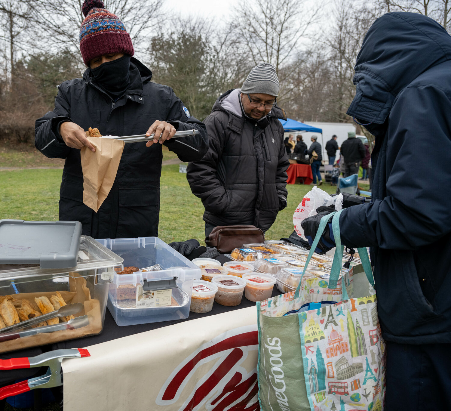 A customer shops at the Tript Foods table for Indian food.