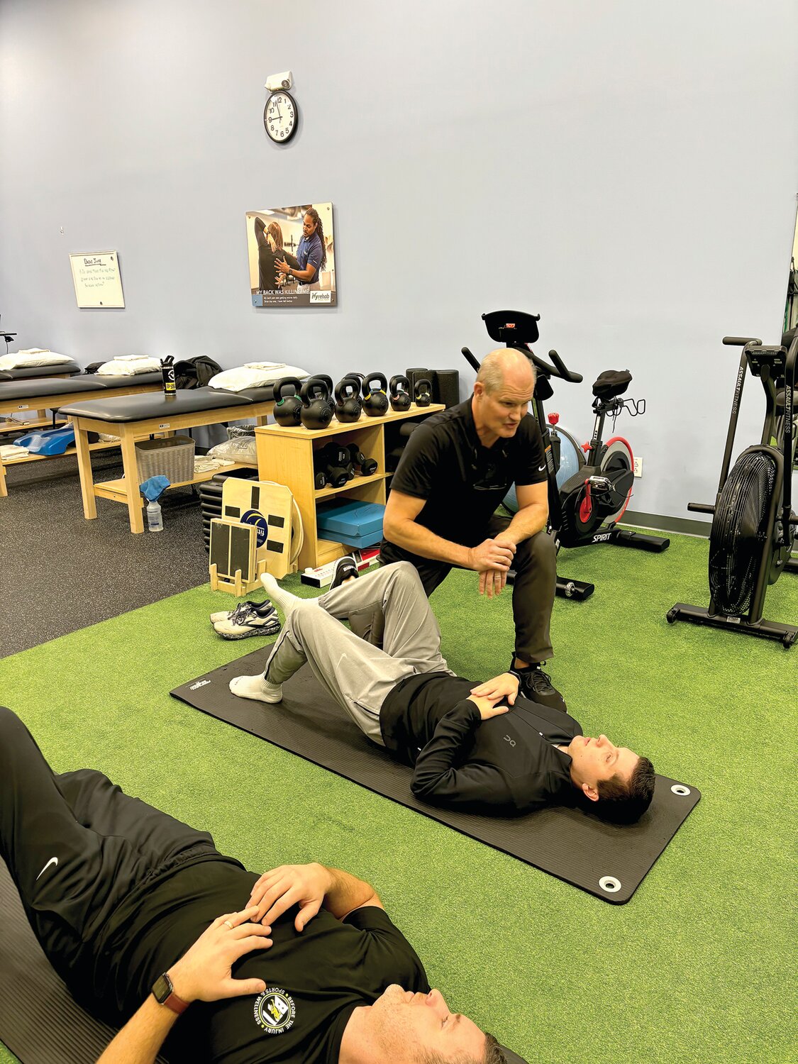 Coach Bob Kaehler, kneeling, works with Tyler Cunningham, right, and Joe Ware.