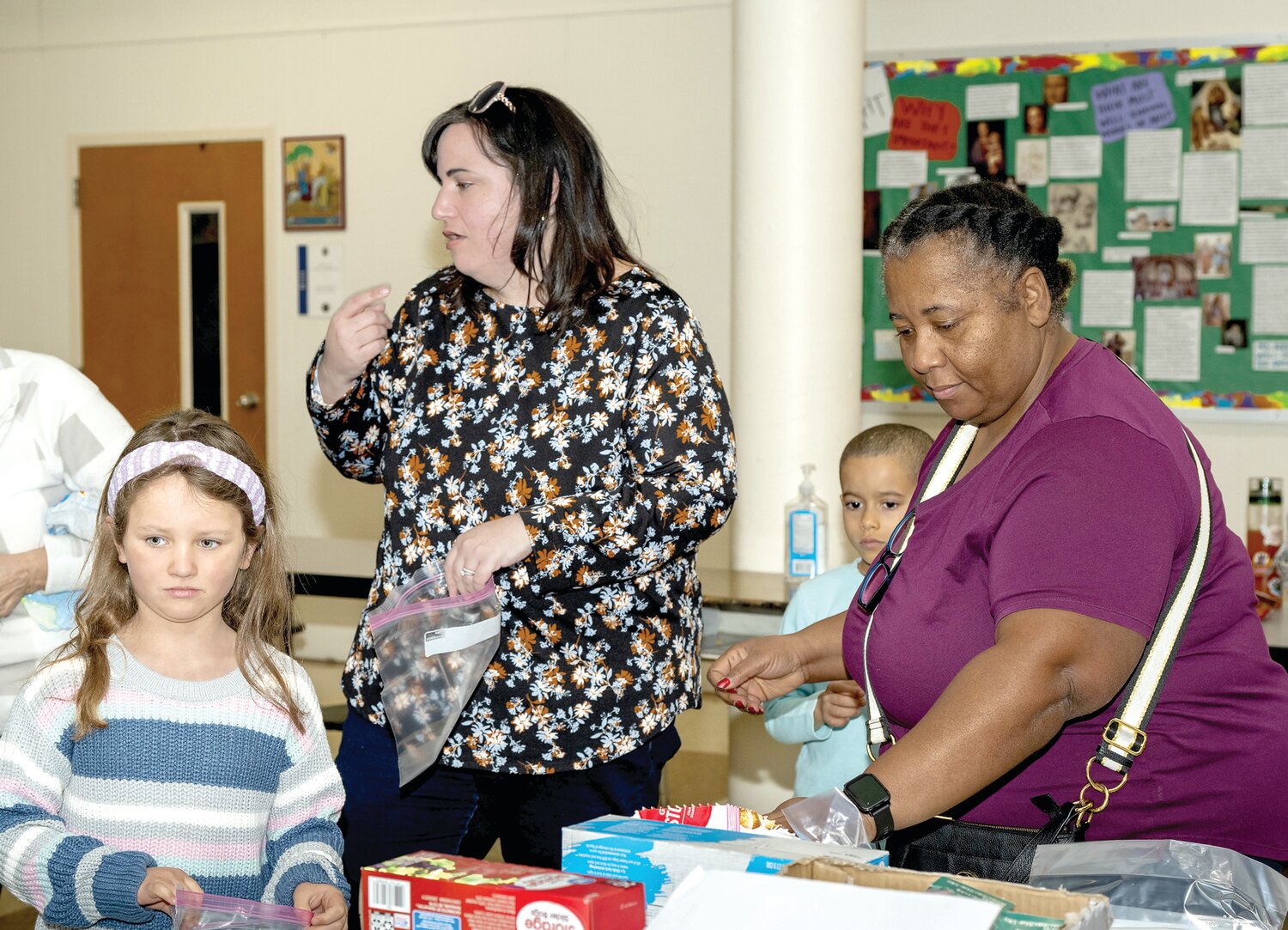 Volunteers pack 739 snack bags in the cafeteria of Our Lady of Grace Catholic School Monday morning in an MLK Day service project.